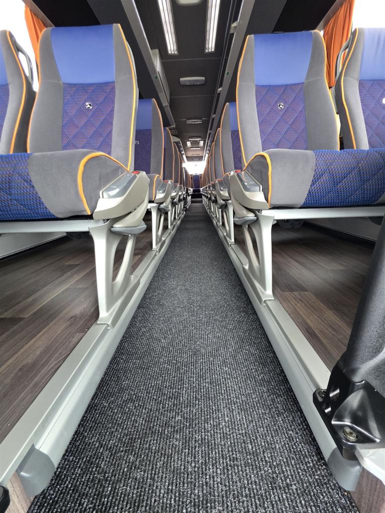 Bus von innen mit blauen Sitzen und braunem Fußboden