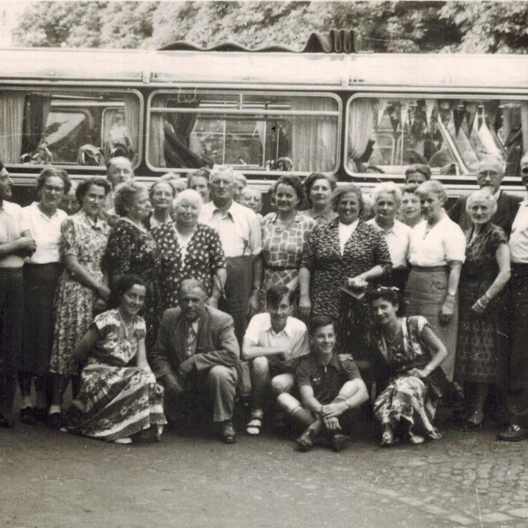 viele Leute vor einem alten Omnibus