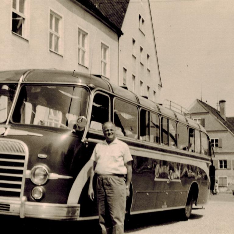 Mann vor einem alten Omnibus