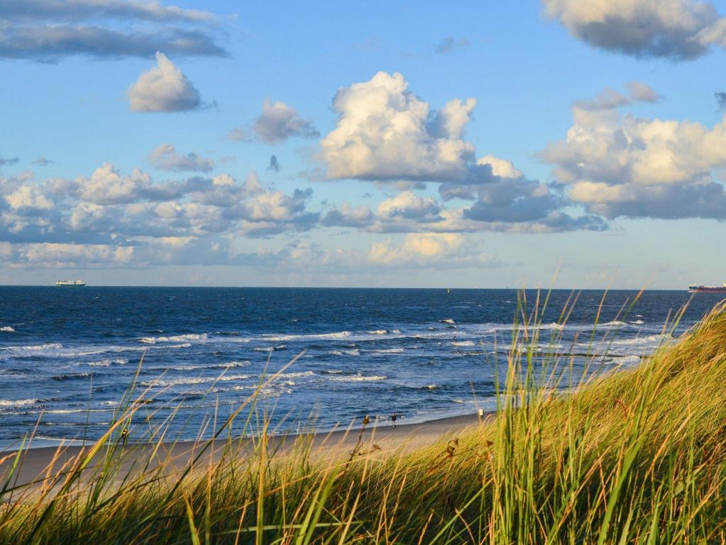Nordseestrand mit Dünen, blaues Wasser und Wolken am Himmel
