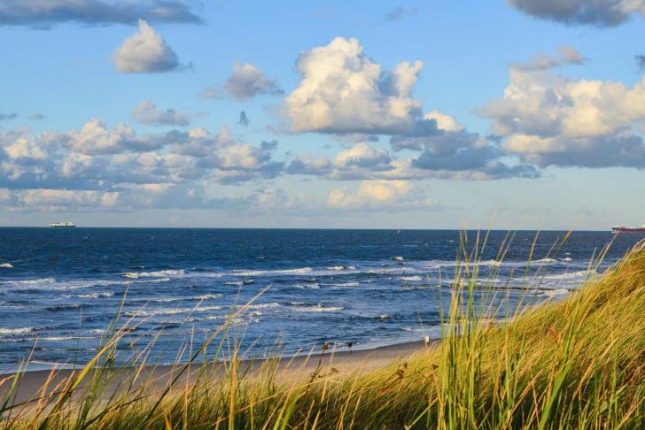 Nordseestrand mit Dünen, blaues Wasser und Wolken am Himmel