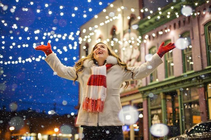 Weihnachten lachende Frau mit Schnee und Lichterketten